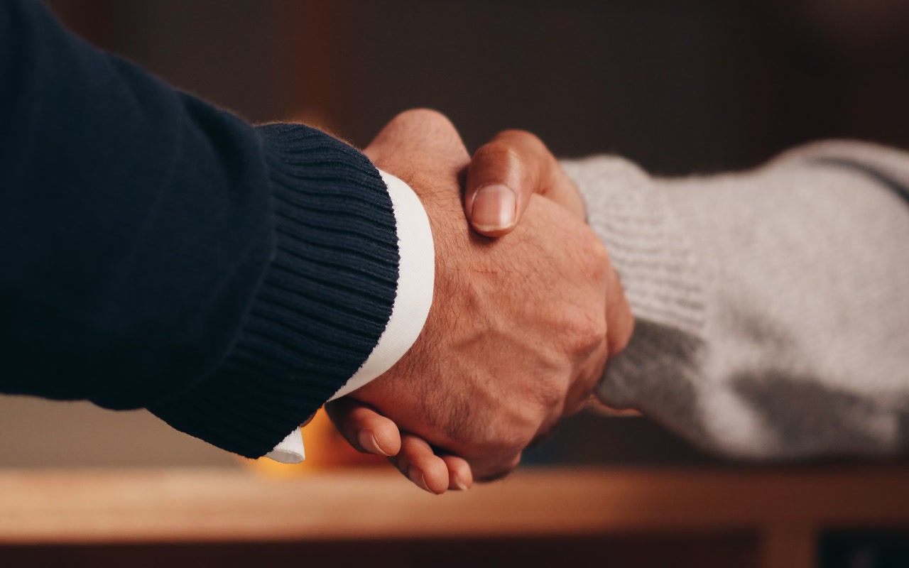 Close-up of two people shaking hands to mark a business agreement