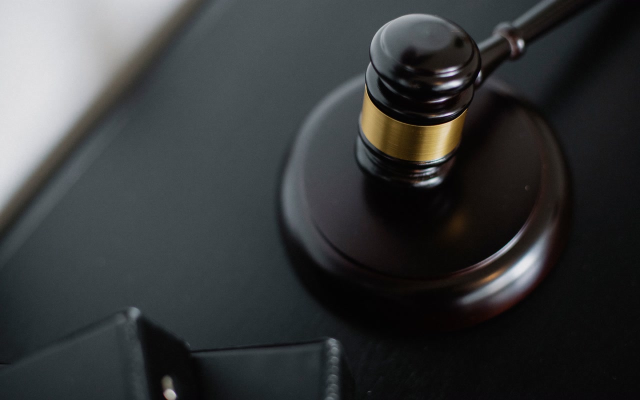 Close-up of a wooden judge's gavel on a dark desk