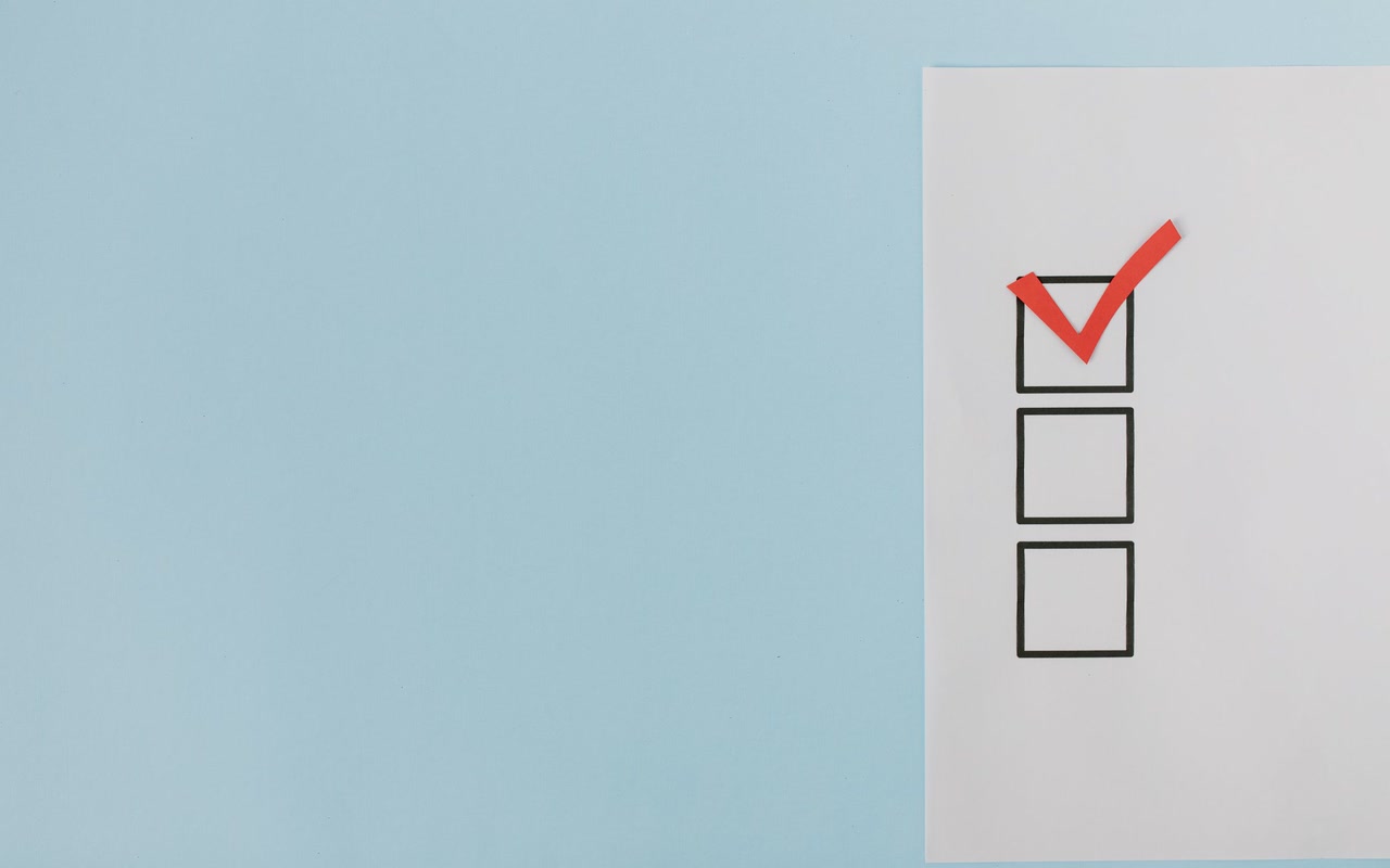 Red check marks filling boxes on a clean blue checklist