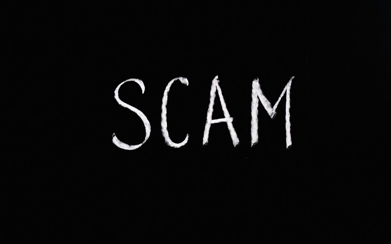 The word SCAM arranged in white letters on a black background