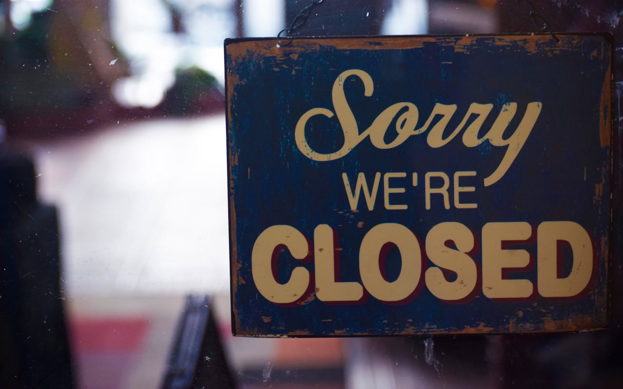 Rustic Sorry We're Closed sign hanging on a shop door