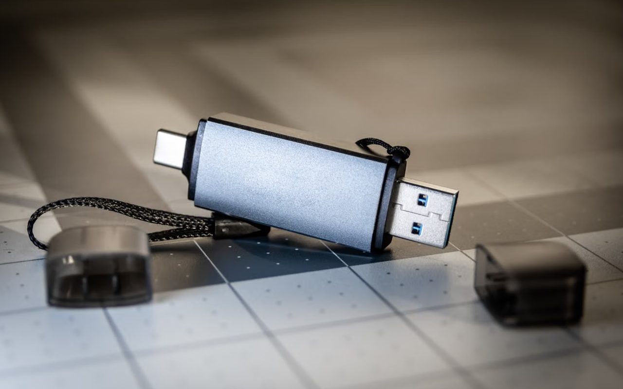 A USB flash drive lying uncapped on a desk surface