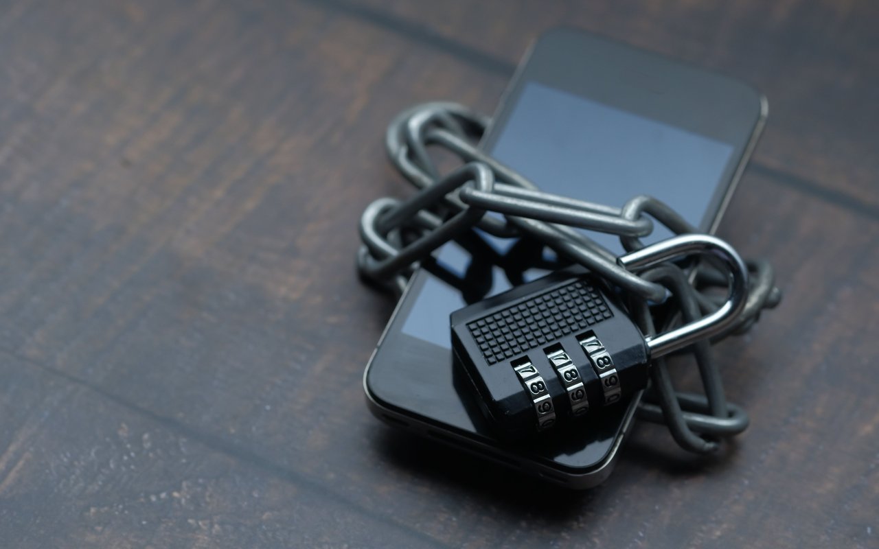 Smartphone wrapped in a chain and secured with a combination lock