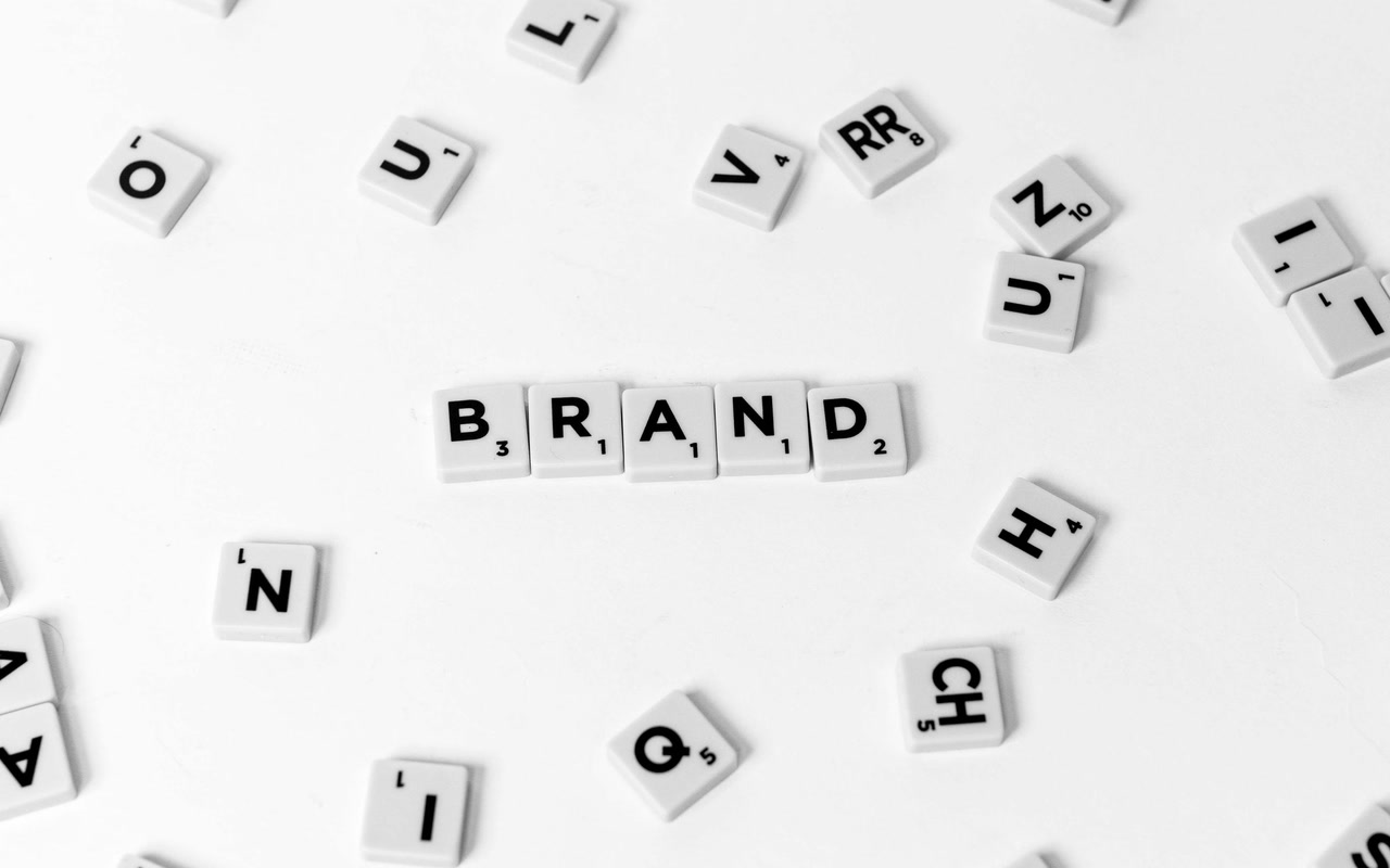 Letter tiles spelling BRAND among scattered letters on a white background