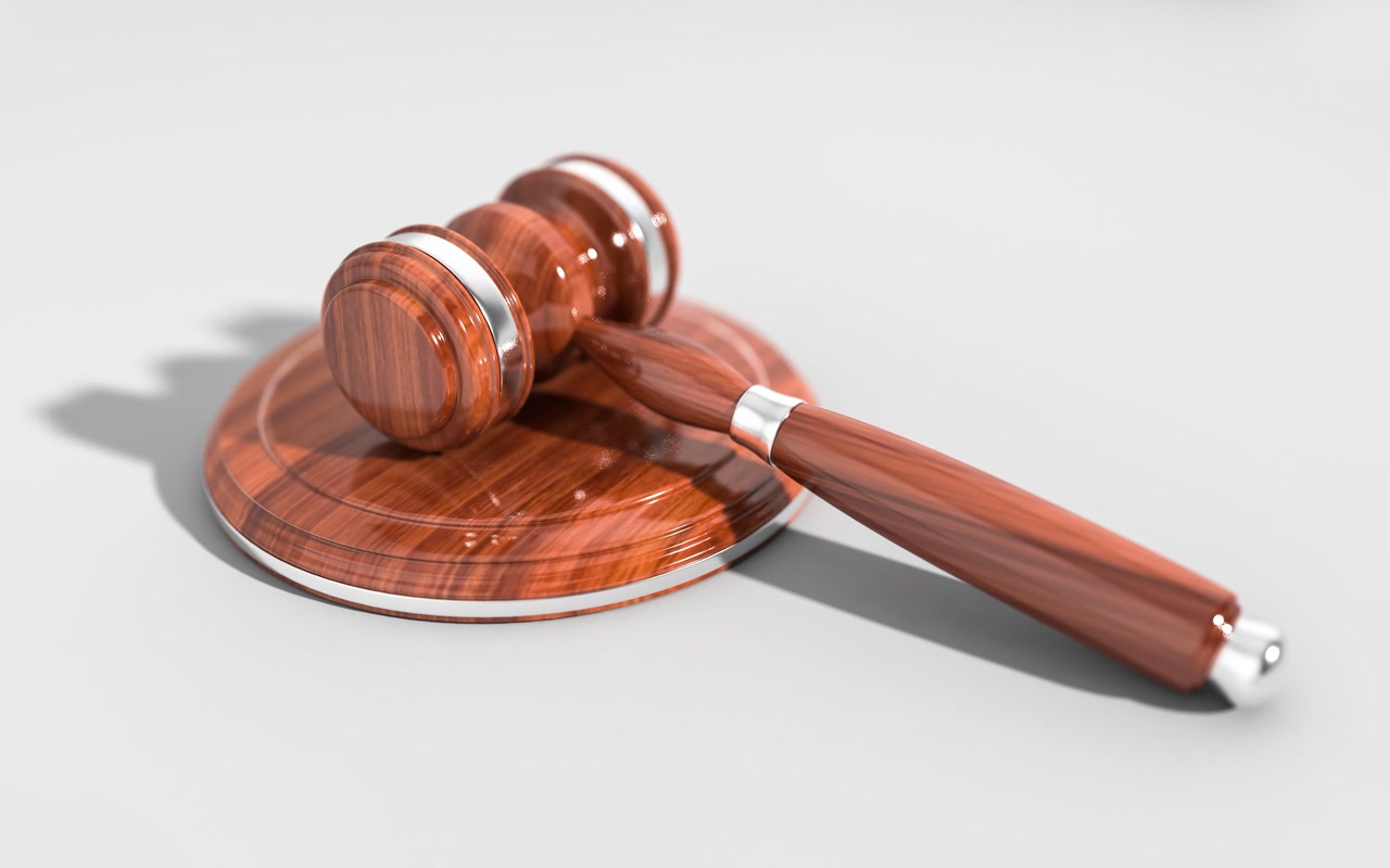 Plain brown wooden judge's gavel isolated against a white background