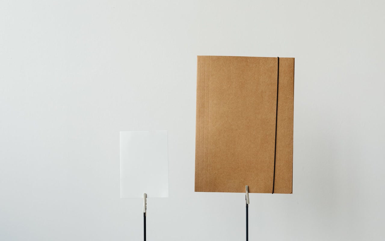 Plain paper folder and blank sheet arranged on a white background