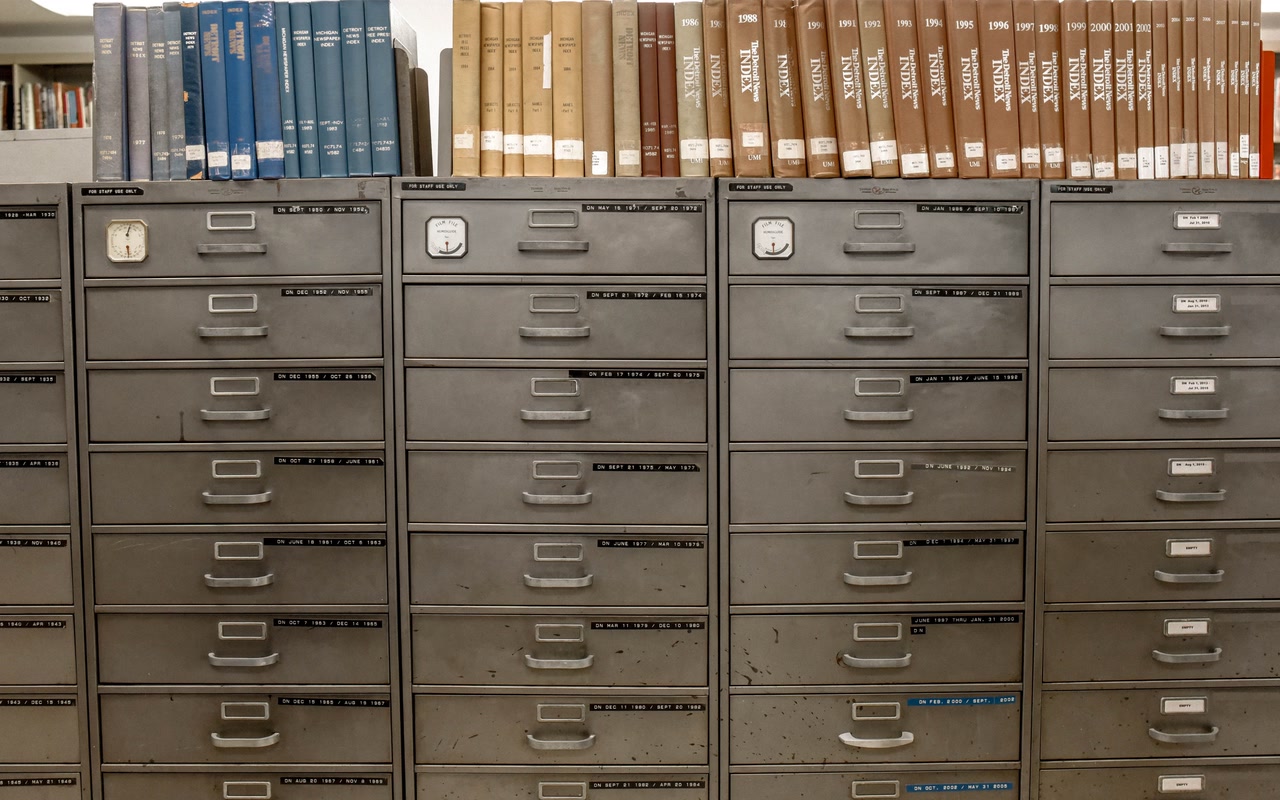 Rows of organised archive drawers and indexed books in a records library