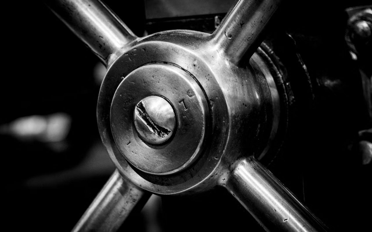 Close-up of a heavy steel vault handle, in black and white